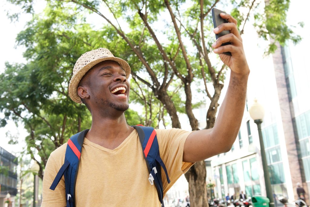 happy african american tourist taking selfie photos